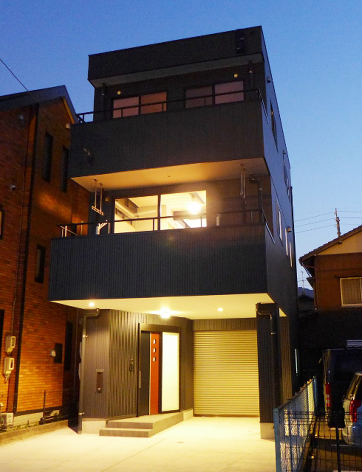 建築システム（狭小住宅専門店）【デザイン住宅、ガレージ、鉄骨鉄筋コンクリート構造】敷地は３０坪ですが、駐車スペース４台分確保。外壁のガルバリウム鋼板、シャープさと重厚感が際立つ。ダーク系は汚れも目立たないのでいつまでも新しく見えるメリットも