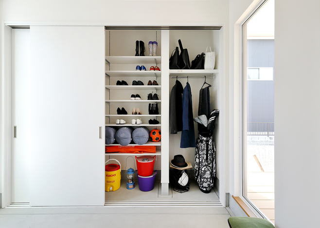 靴やアウター類、趣味のアウトドアグッズも大容量収納できる壁面シューズクローク。扉を閉めておけばスッキリとした空間が保てるのでデザイン性も抜群