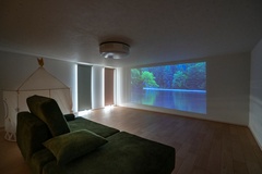 プライベート感あふれるくつろぎの空間。天井に設置したプロジェクターで大画面の映画を楽しめ、リラックスした時間を過ごせる。ロールカーテンを下ろせば、日中でも光を遮れる。