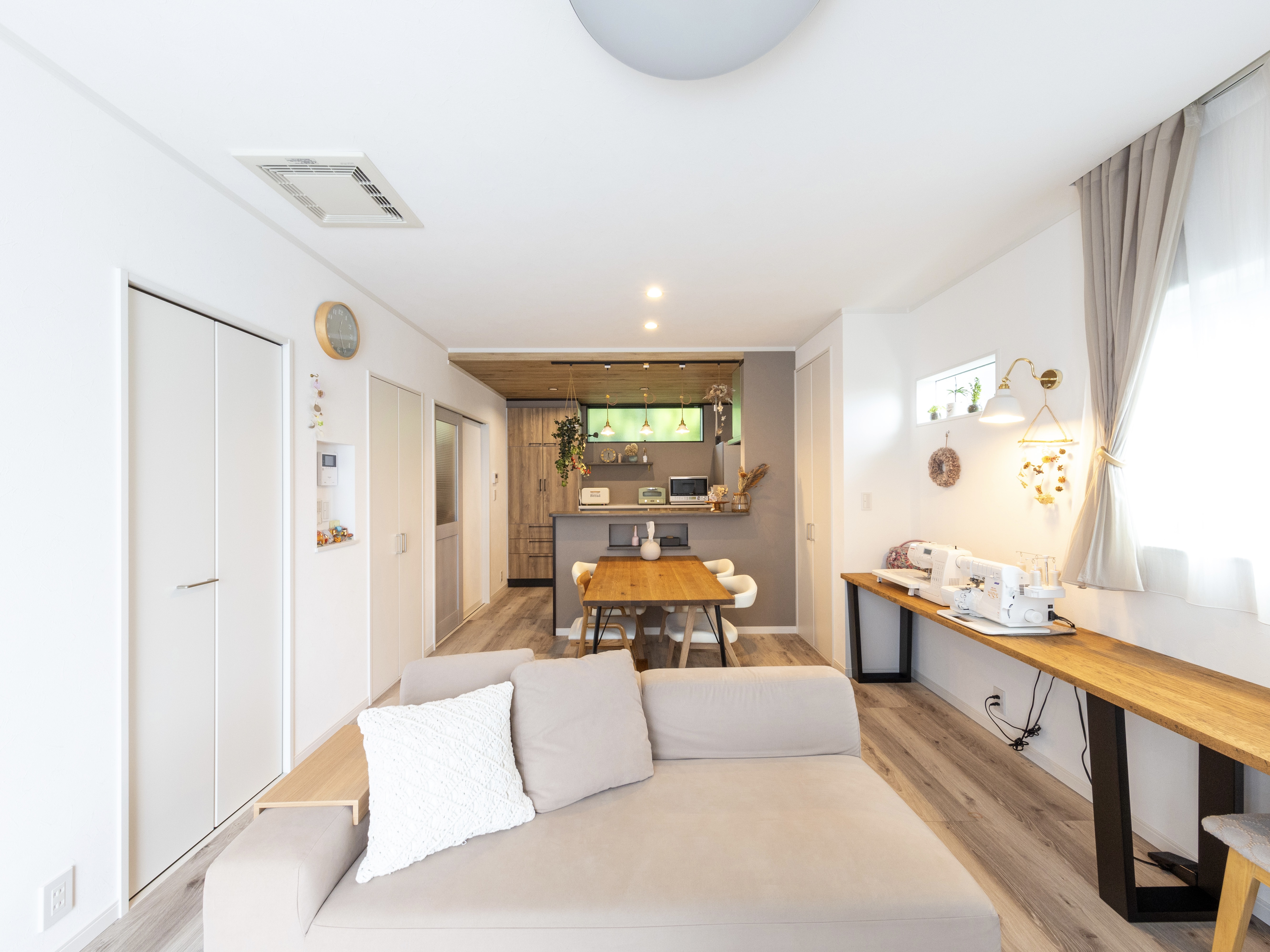 エスホーム｜明るい光が差し込むリビングダイニング。ナチュラルなインテリアが心地良い空間を演出している。ゆったりとしたソファと木製テーブルが調和。