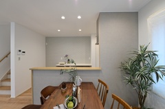 キッチンとつながるダイニングスペース。腰壁がゆるやかにスペースを区切り、手元を適度に隠す設計。