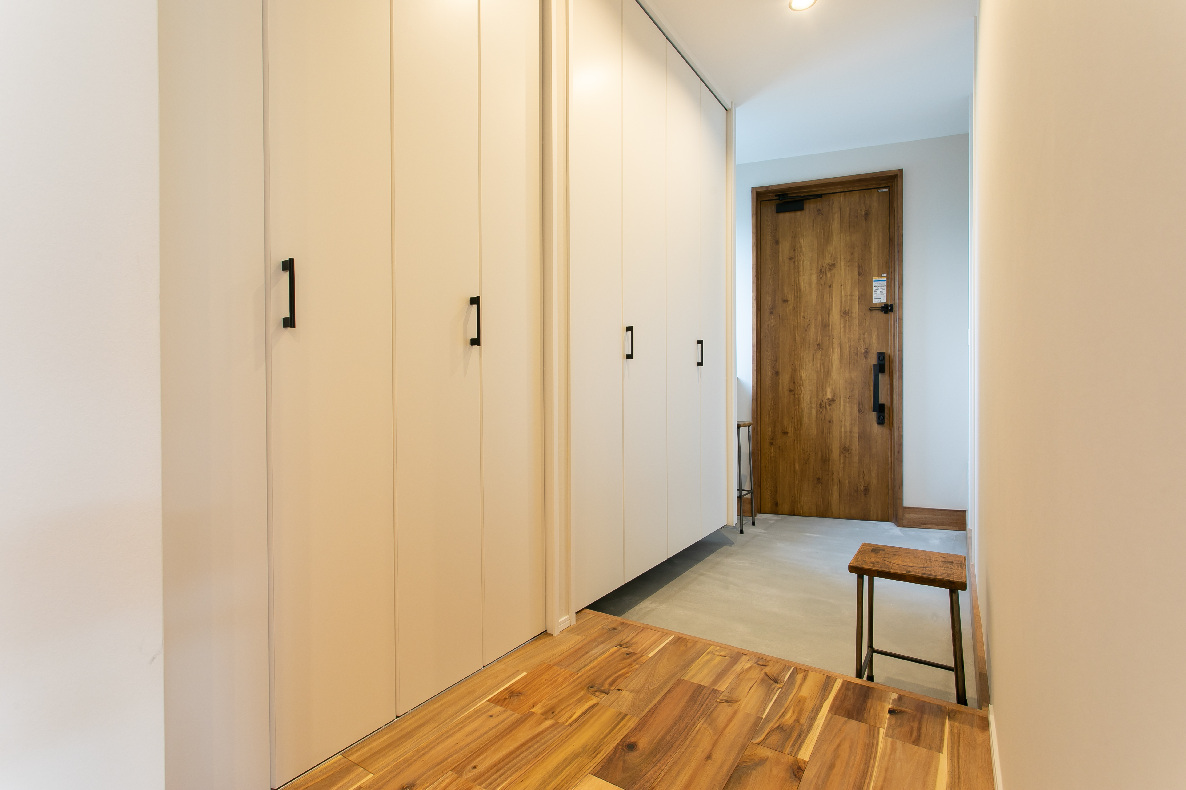 HOME CRAFT｜木目調の床と明るい色合いの収納が特徴の玄関ホール。シンプルながらも温かみのあるデザインが、訪れる人を優しく迎える空間を提供する。