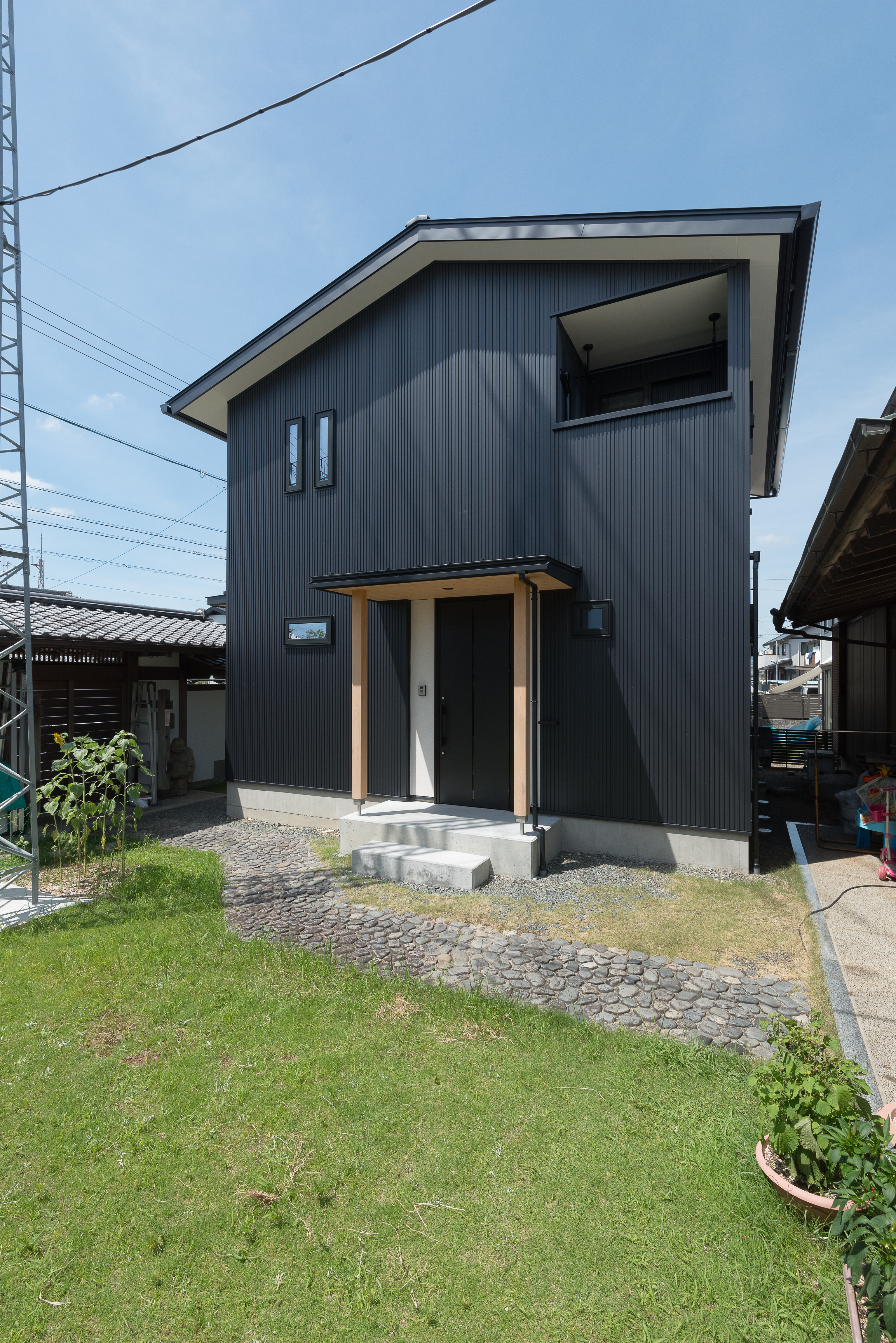 仲田工務店｜落ち着いた色調の外壁が魅力的な二階建て住宅。シンプルながら洗練されたデザインで、居住者に安らぎを提供する。優雅な庭も印象的。