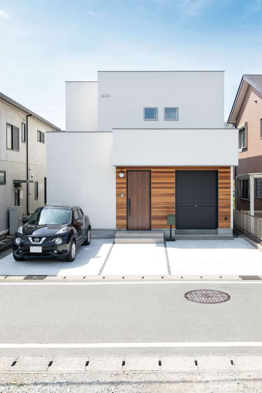 ぽっくハウス静岡（東海ハウス）｜玄関回りは木目調の外壁でアクセント。ロードバイクを置いた物置は内側からも出入り可能。将来はベビーカーも置ける