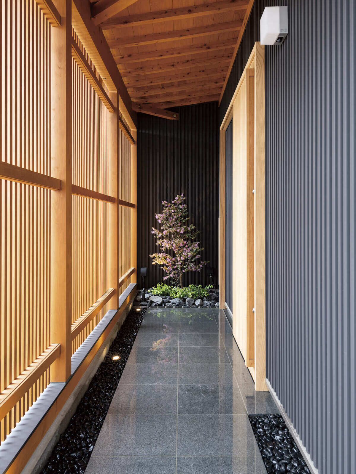 広和木材｜木製の格子と石畳が美しい廊下。自然を感じられる設計で、落ち着いた空間を演出する。