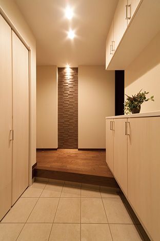 家に入るとまず目に飛び 込むエコカラット(調湿タイル)と間接照明を組み 合わせた壁面装飾