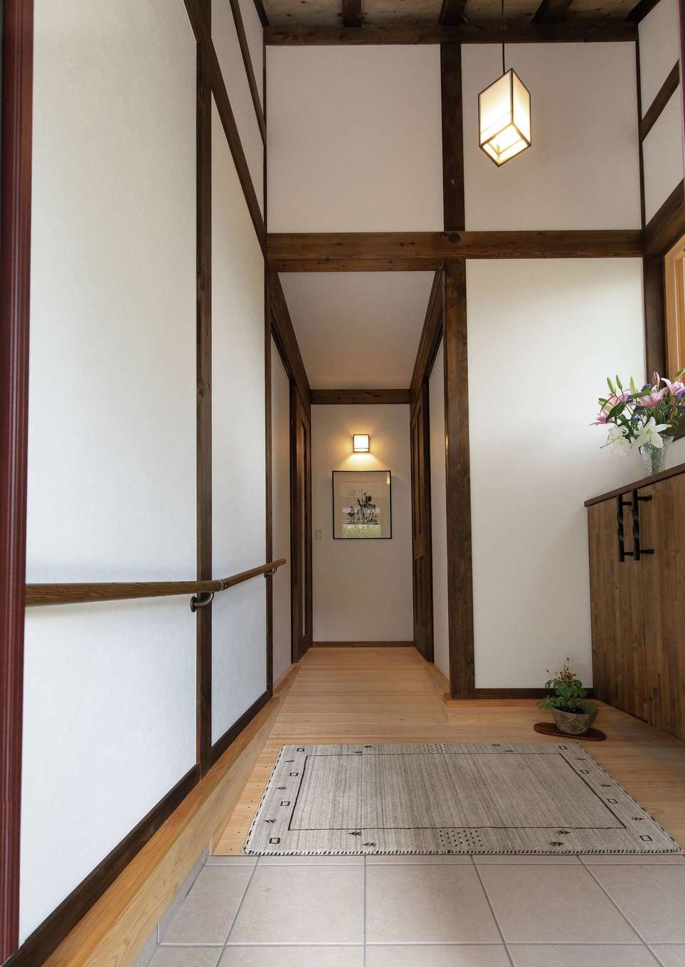 サイエンスホーム【趣味、自然素材、平屋】玄関も勾配天井で、帰宅時の気分も軽やかに。バリアフリーに配慮してあえて框を設けず、スロープ式の玄関を望んだ