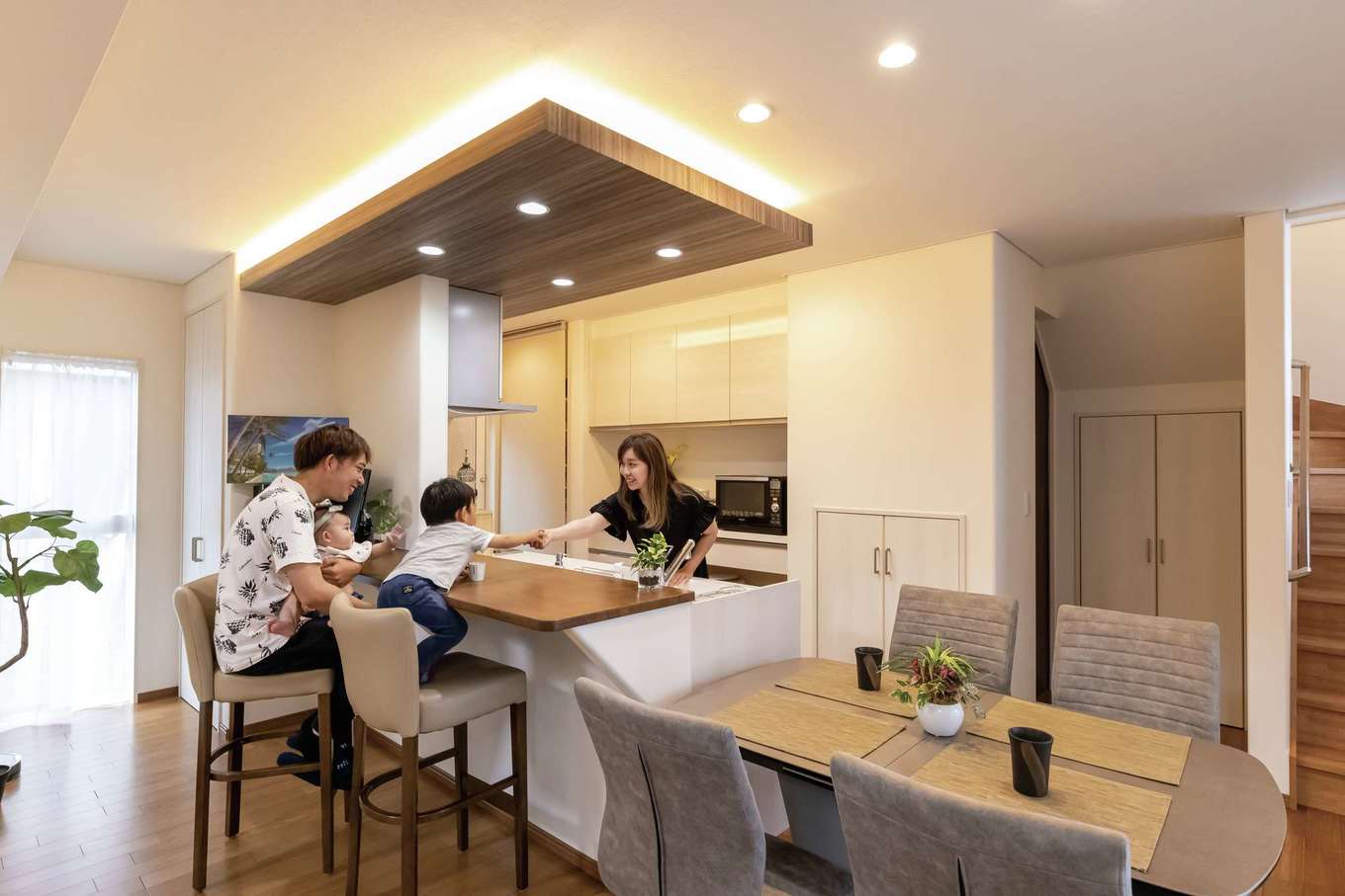住宅工房 アリアンス【デザイン住宅、省エネ、間取り】下がり天井にダウンライトをビルトインしてニュアンスを。キッチンのバックヤードには浴室と脱衣室がある