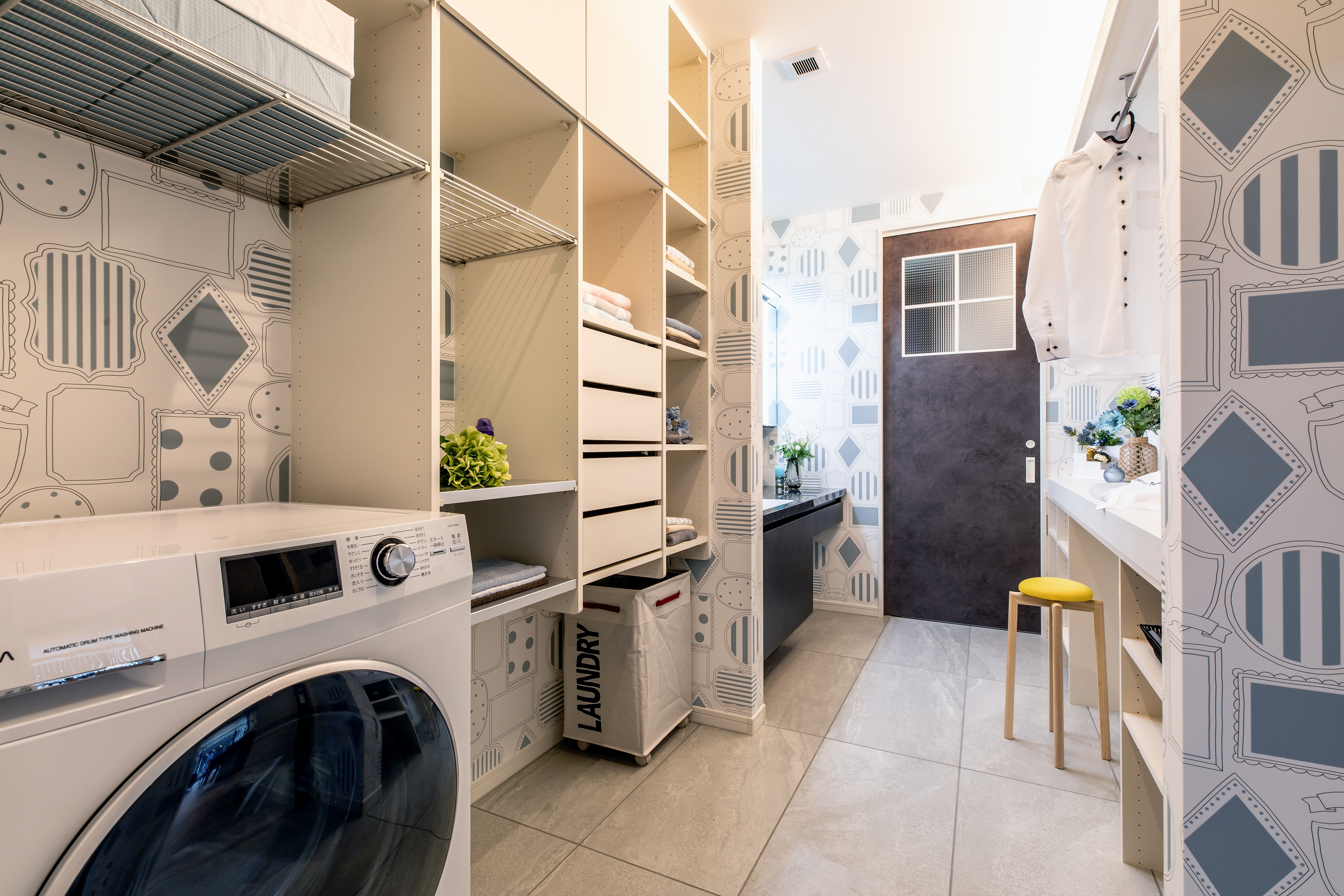 コンチネンタルホーム｜洗面スペースと連結したモダンなランドリールーム。充実した収納スペースとカウンターがあり、家事効率を大幅に向上させるデザインが特徴。