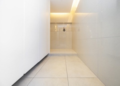 高級感があるスタイリッシュな玄関。ウォークインタイプの収納は設けず、壁面収納にすることで全体にすっきりとした印象となった。家の中へ誘うようにまっすぐに伸びる照明が印象的だ