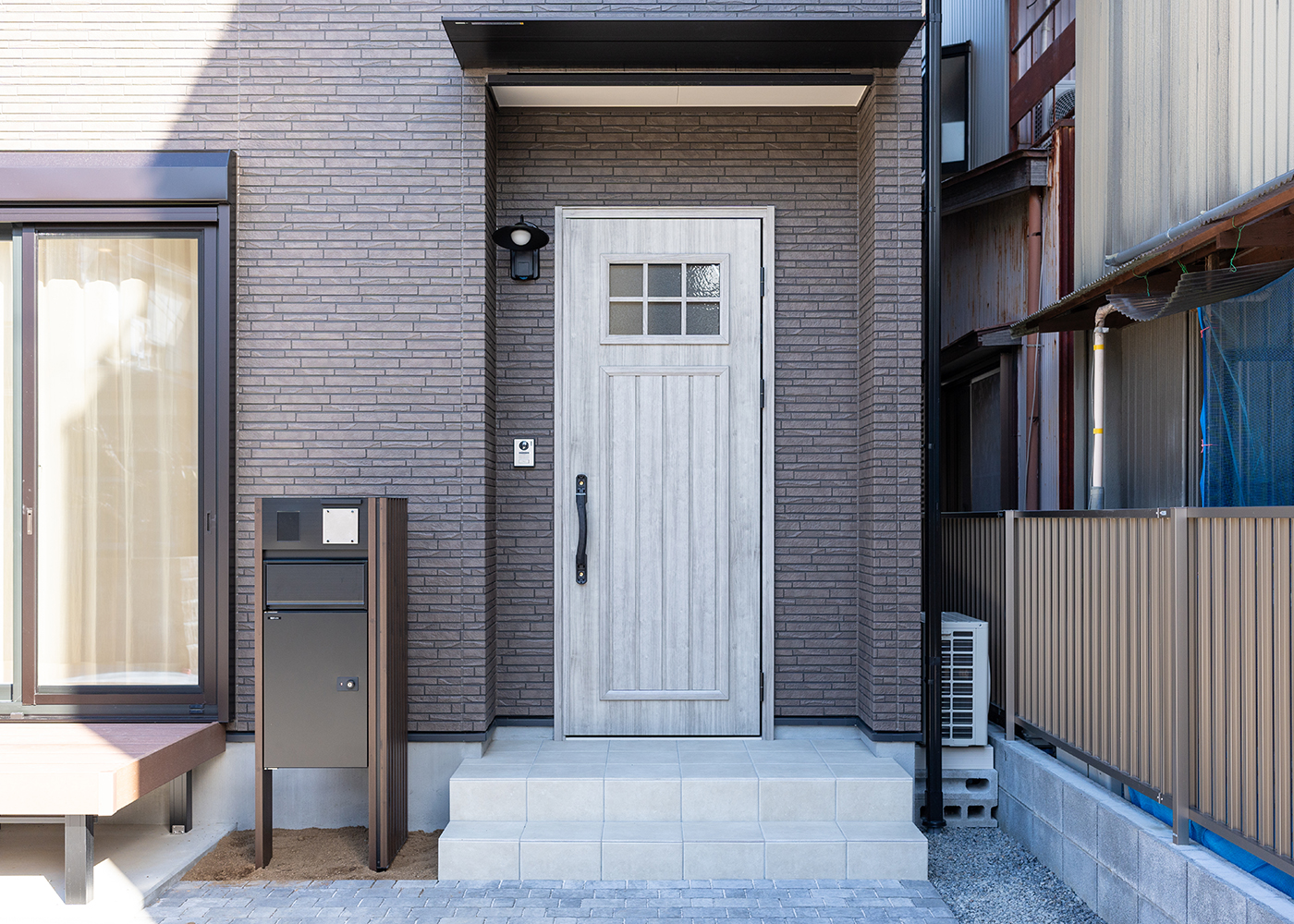 丸宗建設【デザイン住宅、収納力、省エネ】奥さまの好きなカントリー調の白い玄関ドアを採用。共働きで日中は留守にしていることが多いので、宅配BOXも重宝している