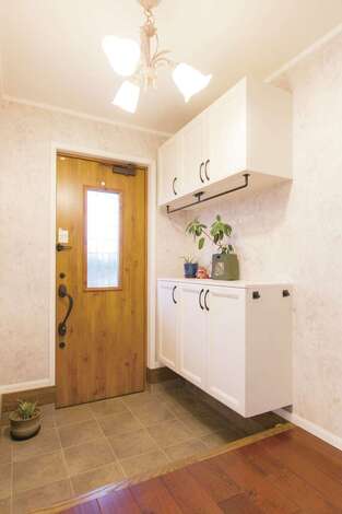 木製のドアとシューズボックス、シャンデリアは夫婦で吟味して選んだもの。コンセプトは“あたたかい家”