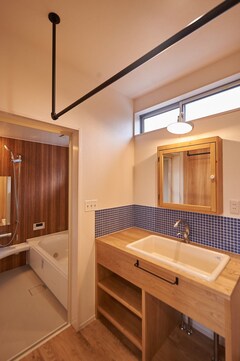 陶器の流しに合わせて造作した洗面台。周囲にはタイルを貼ってかわいらしく仕上げた