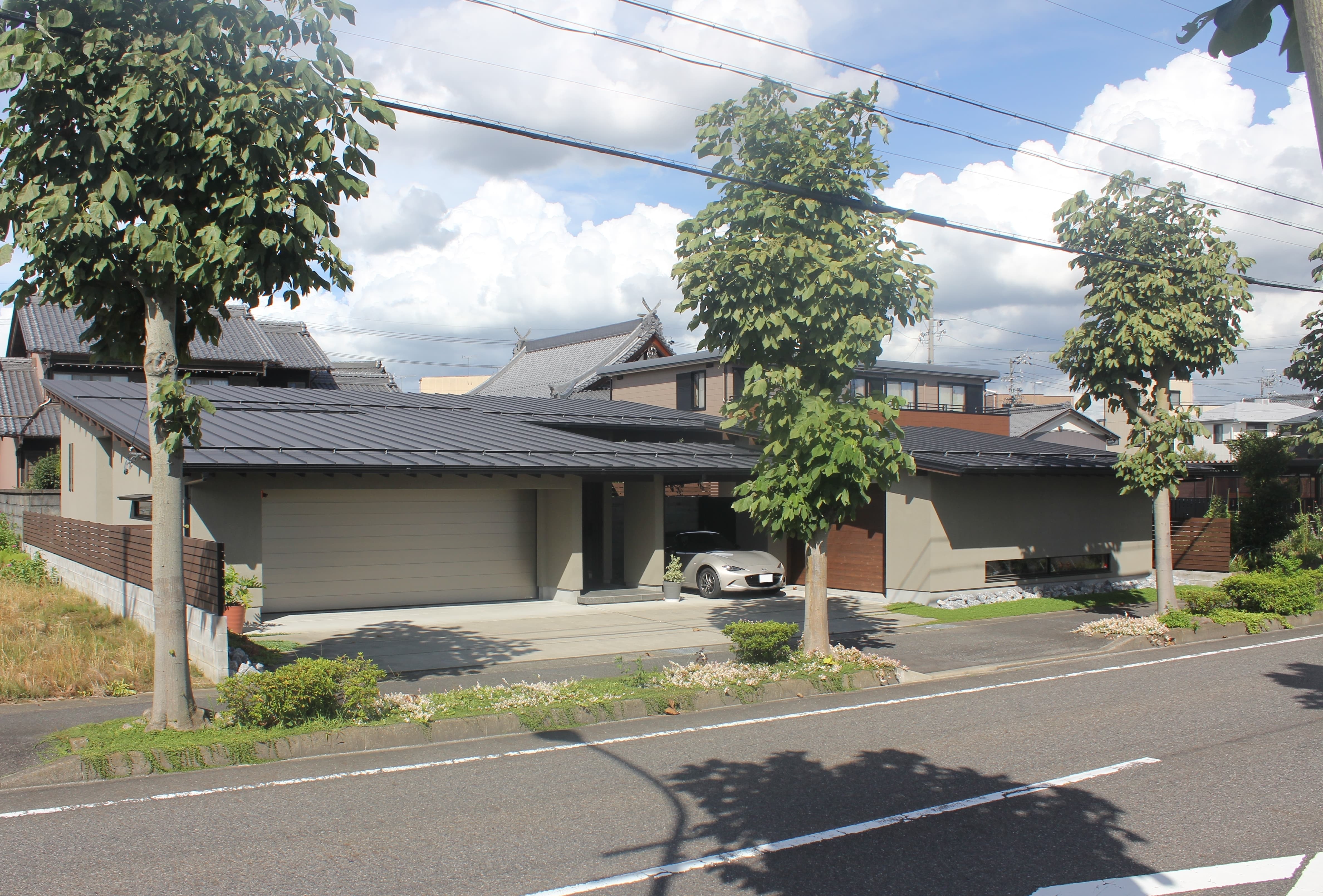 安田住宅｜安田建築設計室｜緑溢れる並木道沿いに建つ、シンプルかつモダンな外観。ガレージが一体となっており、便利で洗練されたデザインが印象的である。