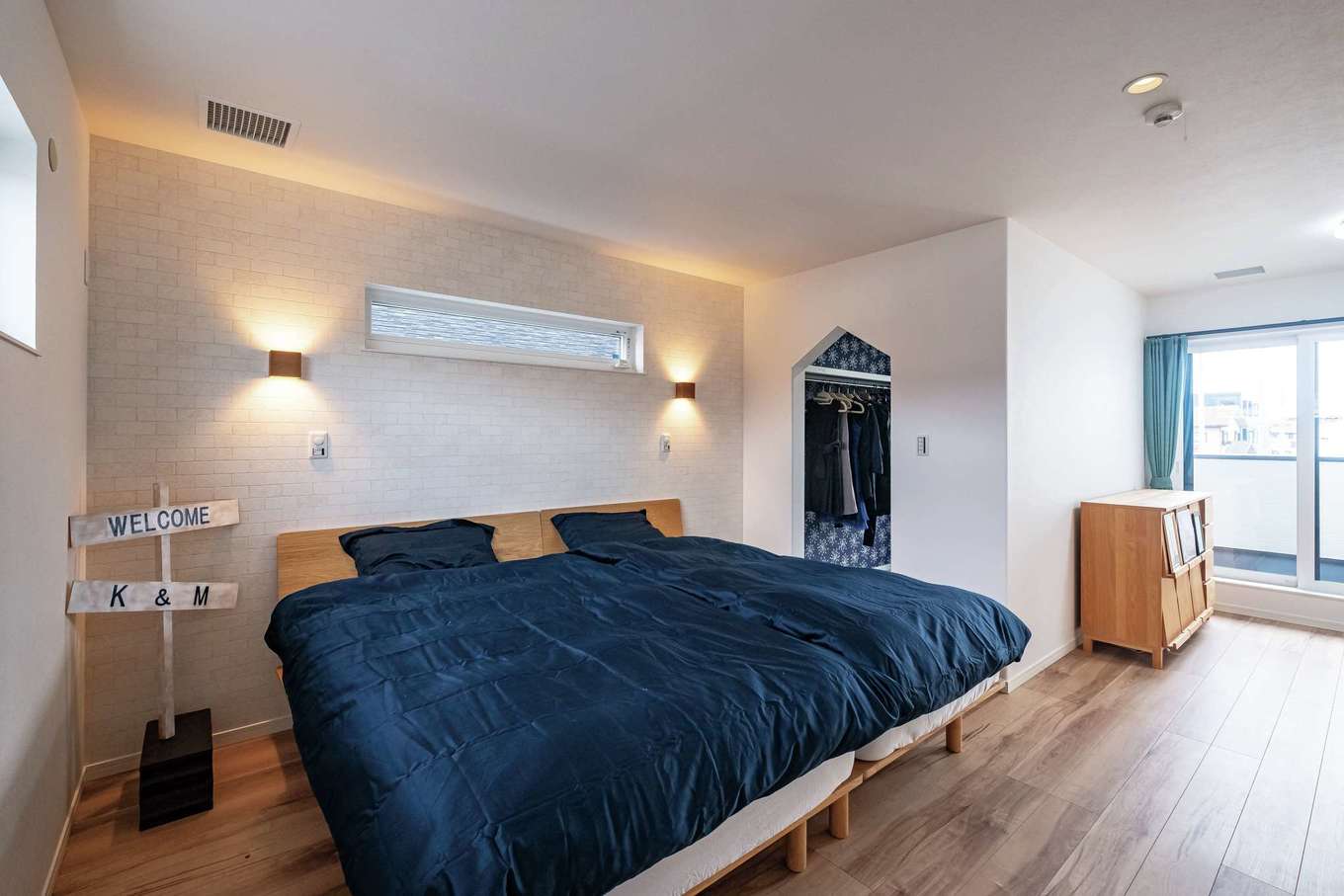 イデキョウホーム【子育て、収納力、省エネ】寝室は将来仕切って子ども部屋を作ることも可能。ウォークインクローゼットは入口の形に注目。中は壁紙で思い切り遊んだそう