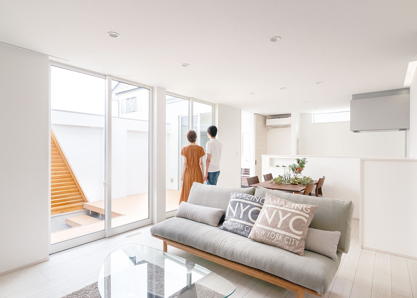 Touch House（タッチハウス）【デザイン住宅、夫婦で暮らす、間取り】白を基調としたLDKは中庭と天井まであるハイサッシでつながる光満ちる空間。ソファに腰掛けたとき、視線が空へと抜ける