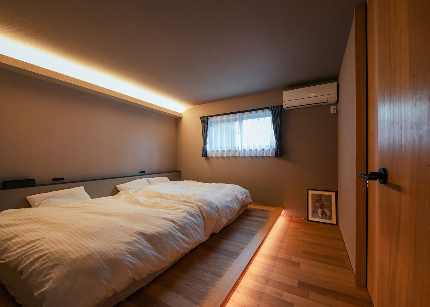 アイ工務店 愛知【デザイン住宅、間取り、平屋】天井と足元に間接照明を取り入れ、落ち着いた雰囲気に仕上げた寝室。右の引き戸を開けると書斎へ