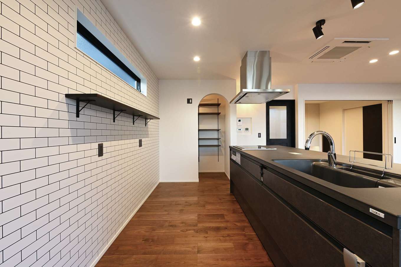 REIWA HOUSE（令和ハウス）【デザイン住宅、省エネ、間取り】奥さまお気に入りのアイランドキッチンを起点とした家事ラク動線。白いタイル調のクロスがアクセントに