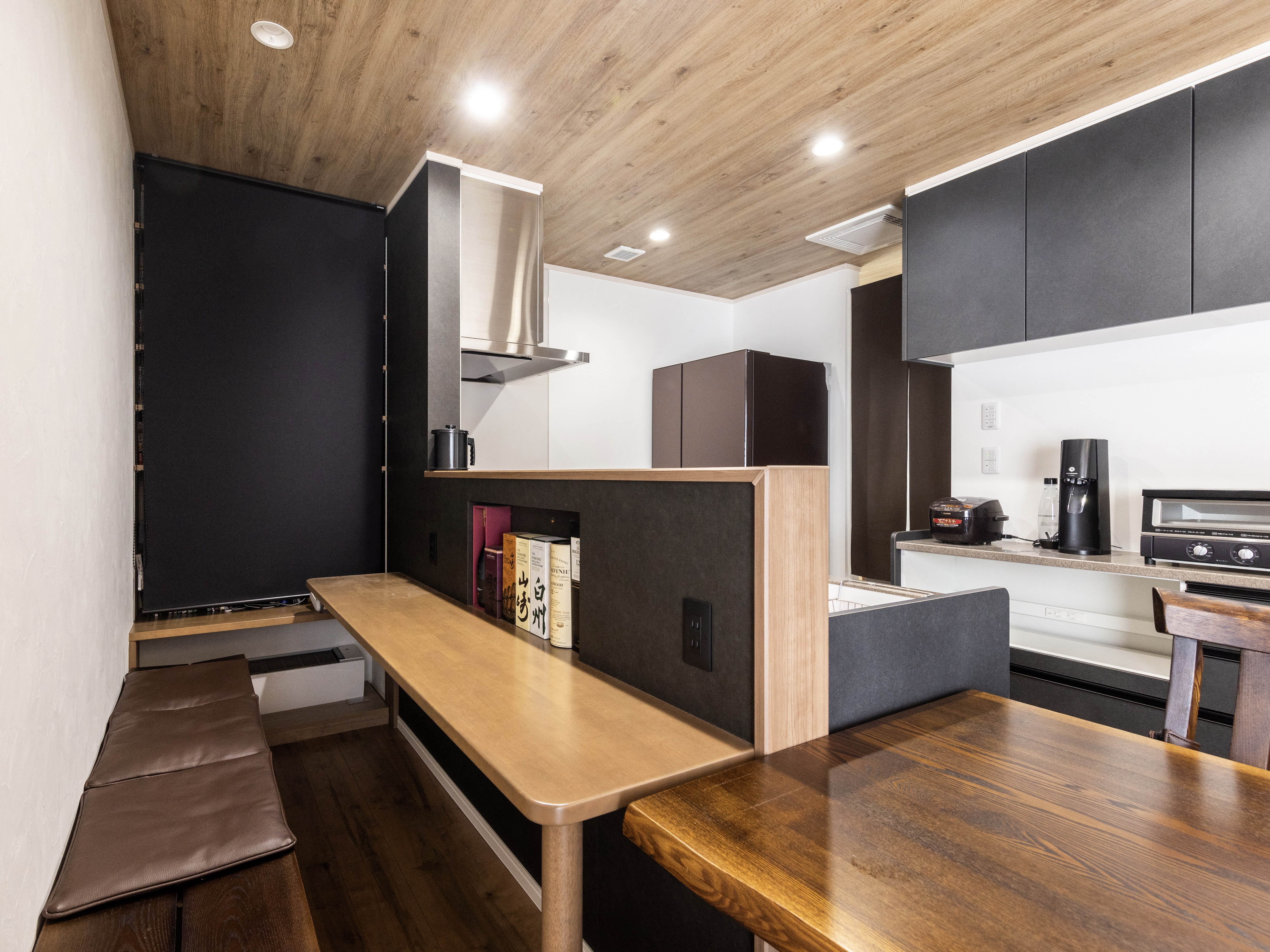 エスホーム｜木目調の天井が暖かみを演出するリビングダイニング。対面カウンターと一体化したダイニングテーブルが、家族のコミュニケーションを促進するデザイン。キッチン反対側はバーカウンター風に作り、子供用のスタディーカウンターにもなる。