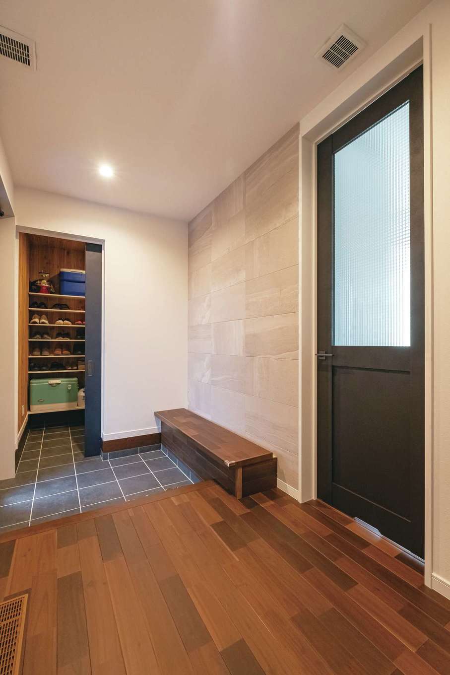 イデキョウホーム【省エネ、間取り、屋上バルコニー】たっぷりのシューズクロークを備えた玄関。ベンチの下も収納になっている。正面の壁には調湿、脱臭機能をもつエコカラットを採用