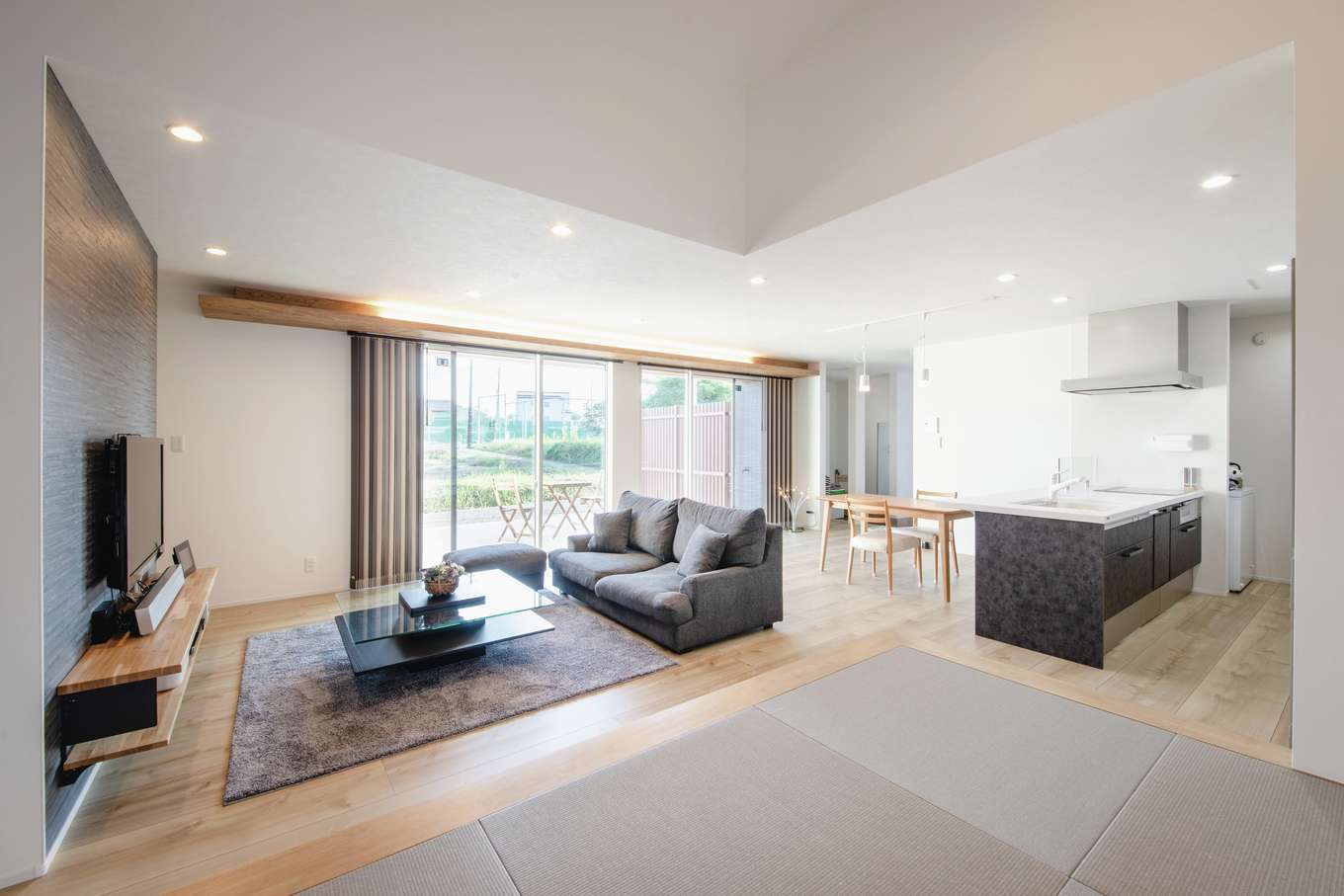 吉川住建【デザイン住宅、夫婦で暮らす、平屋】遮るものが何もない約22畳のLDK。目線が遠くへ抜けていき、より開放的に感じられる。幅の広いフローリングはPanasonic・アーキスペックフロア。小上がりの畳コーナーは来客をもてなしたり、ゴロンと横になったり