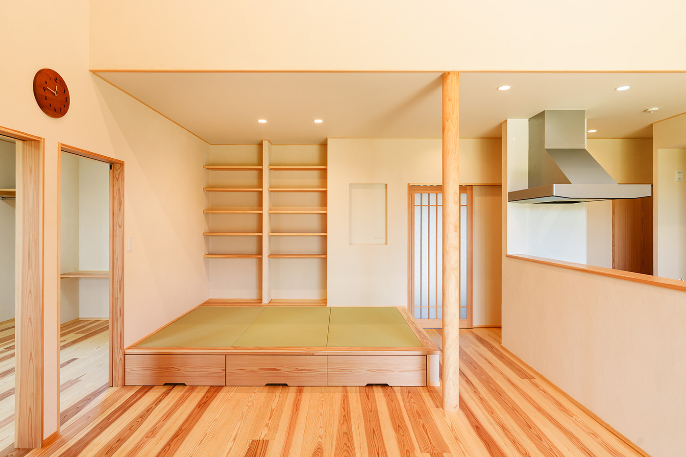 アンシンハウズ【自然素材、間取り、平屋】キッチンから見える位置に設けた小上がりの畳コーナー。造作の棚はランドセルや教科書を収納するなど多用途に使えそう。畳の下は収納スペース。隣接する子ども部屋の引き戸を開けておけば、子ども部屋の延長のような感覚でくつろぐことも可能だ