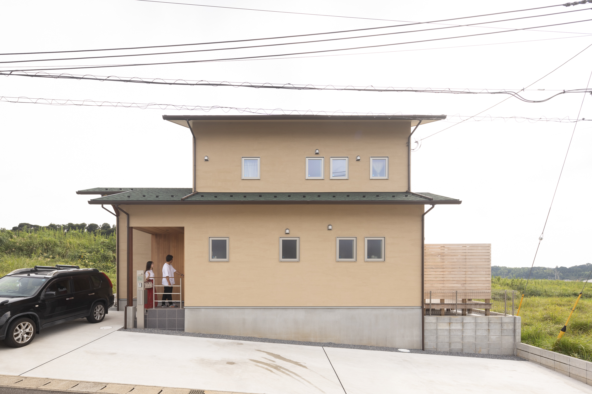 木粋舎 一級建築士事務所｜自然に囲まれたシンプルな二階建ての外観。暖かい色合いの外壁が周辺の景観と調和し、落ち着いた雰囲気を醸し出している。