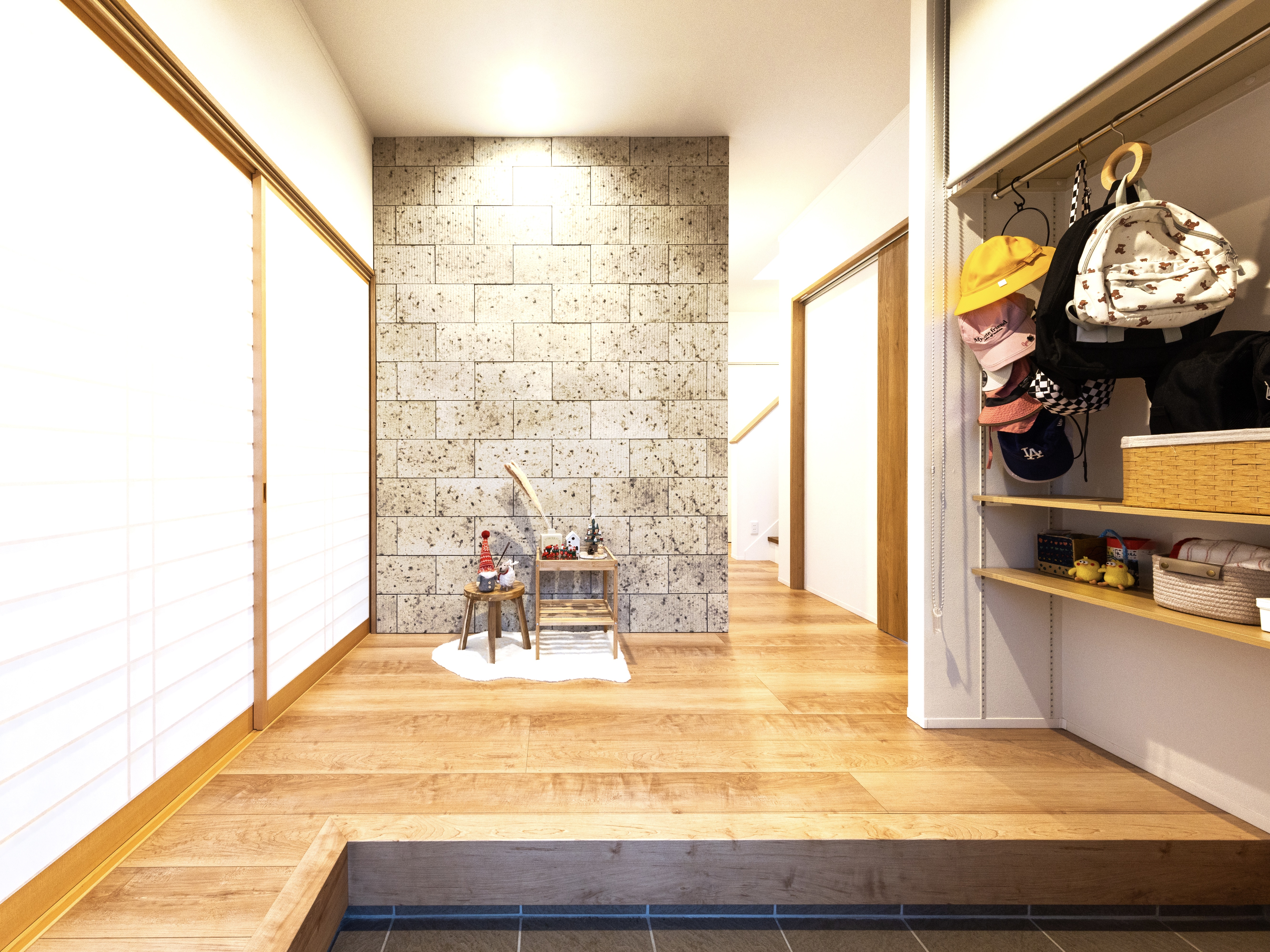 エスホーム｜玄関正面には、大谷石風のタイル。広い上にL字方の框があるため、家族全員で同時に準備して出かけられる。