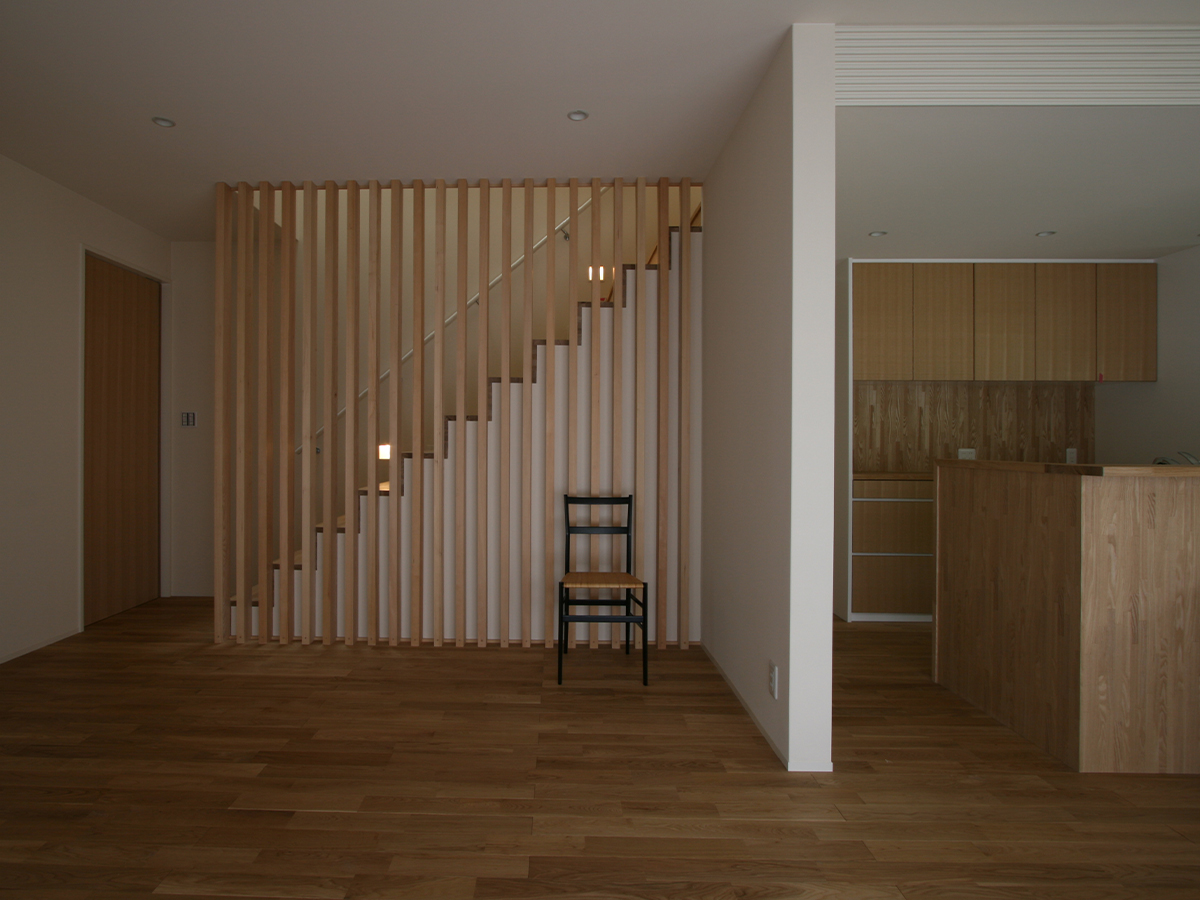 斉藤工務店｜開放的なLDKは、階段の格子デザインがアクセント。木の素材感が空間に温かみをもたらし、居心地の良い空間を演出する。