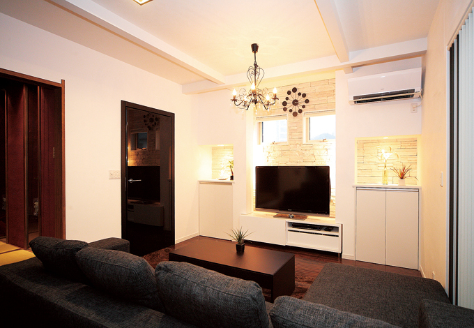 通常は外壁に使う石をリビングの壁に。TVを中心に窓や造作 をシンメトリーに配置し、調和のとれたデザインに