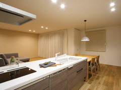 シンプルで明るいLDK。広々としたキッチンカウンターが特徴で、リビングとダイニングスペースが一体化し、開放感を演出している