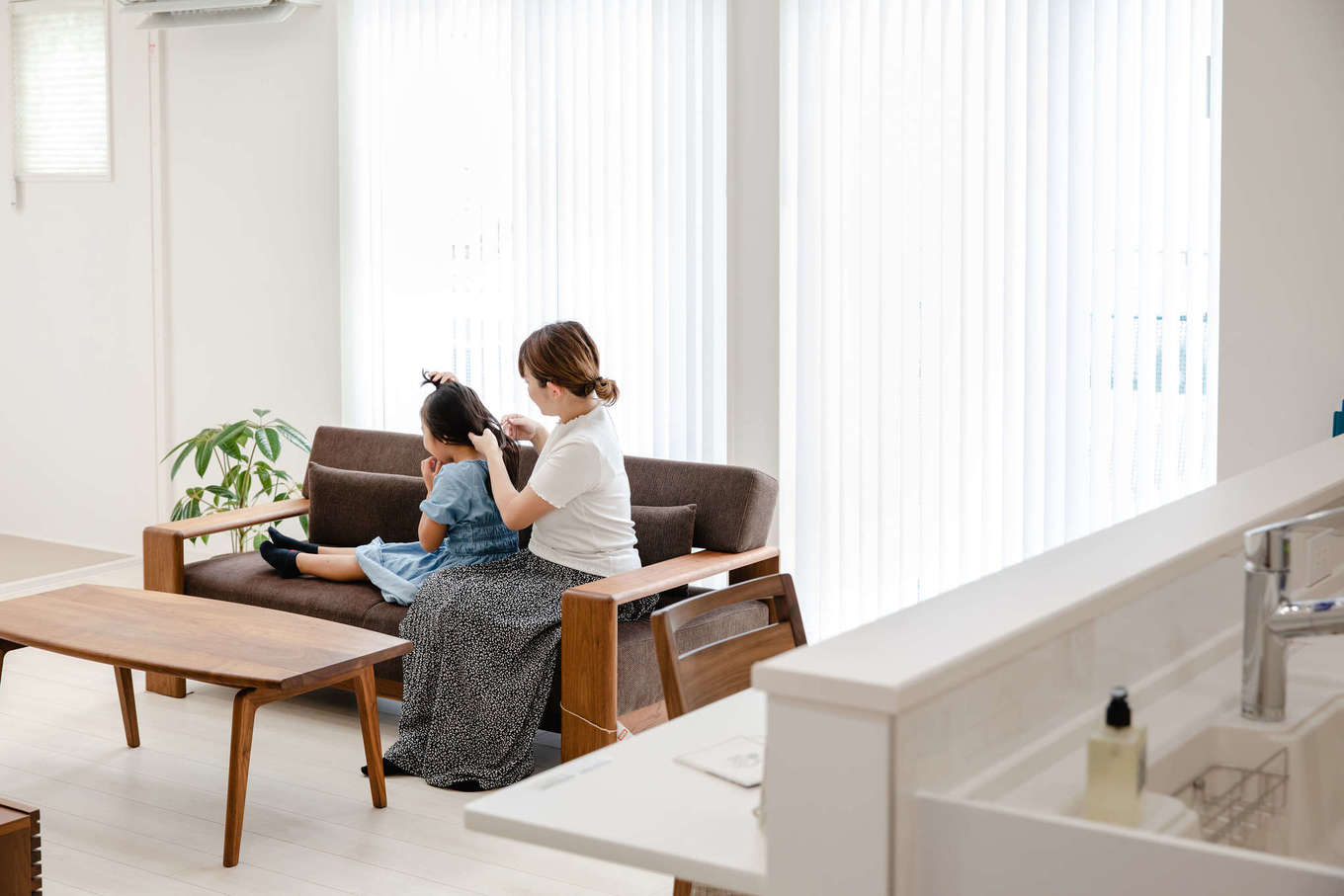 子育て安心住宅＆デザインラボ【デザイン住宅、子育て、間取り】カーテンごしに柔らかな光が注ぐリビングで、子どもとくつろぐひととき。高気密・高断熱の構造に加えて床下エアコンを導入し、室内は年中快適