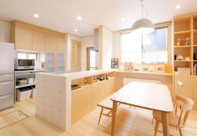 奥さまお気に入りのタイル貼りのキッチン。カウンターや本棚も雰囲気に合わせて造作された。冬場が苦手というご夫婦は、建物をじんわりあたためる蓄熱暖房を採用