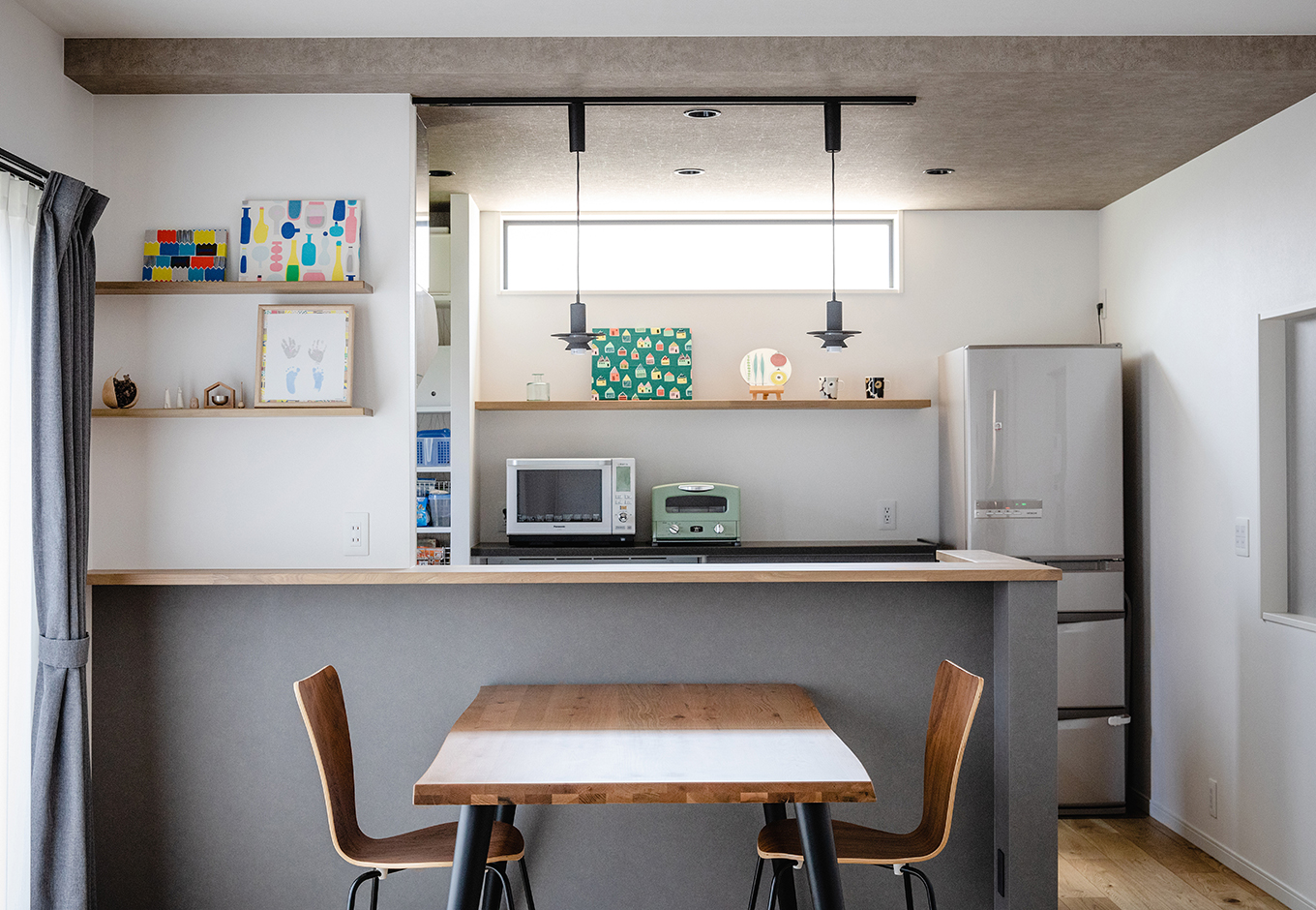 カナメクラフト（かなめ創建）【デザイン住宅、子育て、間取り】カフェスタイルのオープンキッチン。ペンダントライト、ニッチ、冷蔵庫もグレーで揃えた