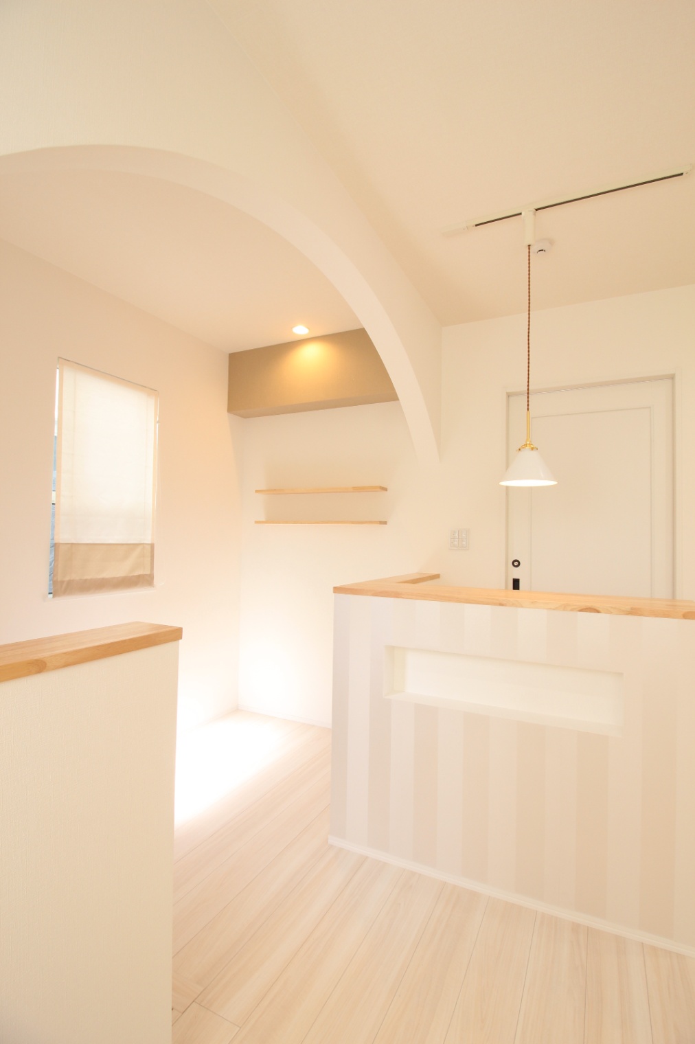 小野田産業～designers house project～｜アーチ状の天井が特徴的な明るい店舗用の玄関ホール。白を基調とした内装が開放感を演出し、落ち着いた空間を実現している。