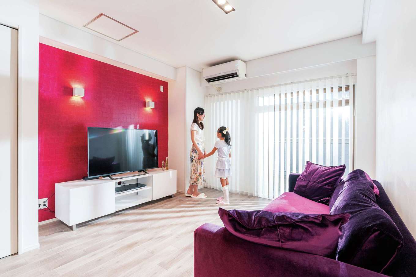 nattoku住宅｜グレーの無垢の床にテレビステーションの赤いクロスが映えるイタリアンモダンのリビング。ソファとAVボードも『納得』オリジナル