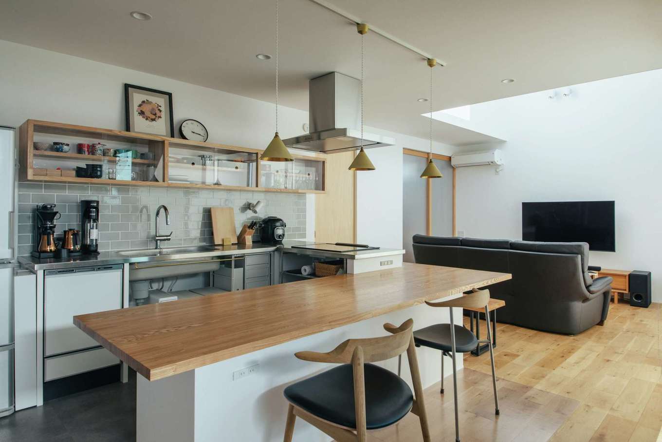  ソラマド浜松【デザイン住宅、子育て、間取り】『ソラマド』の代名詞とも言えるコの字型キッチンを中心にレイアウトしたLDK。夫婦ともに高身長なのでキッチン側の床は下げず、IHクッキングヒーター部分を高くして機能性を高めた