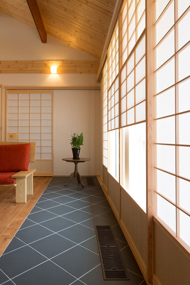 建築システム（狭小住宅専門店）【和風、夫婦で暮らす、平屋】真南に設計されたリビングの窓際はまるで旅館の広縁のようなたたずまい。内障子から柔らかな光が余暇の時間を包み込む。黒いタイルのスリットは全館空調システムの吹き上がり口となっている