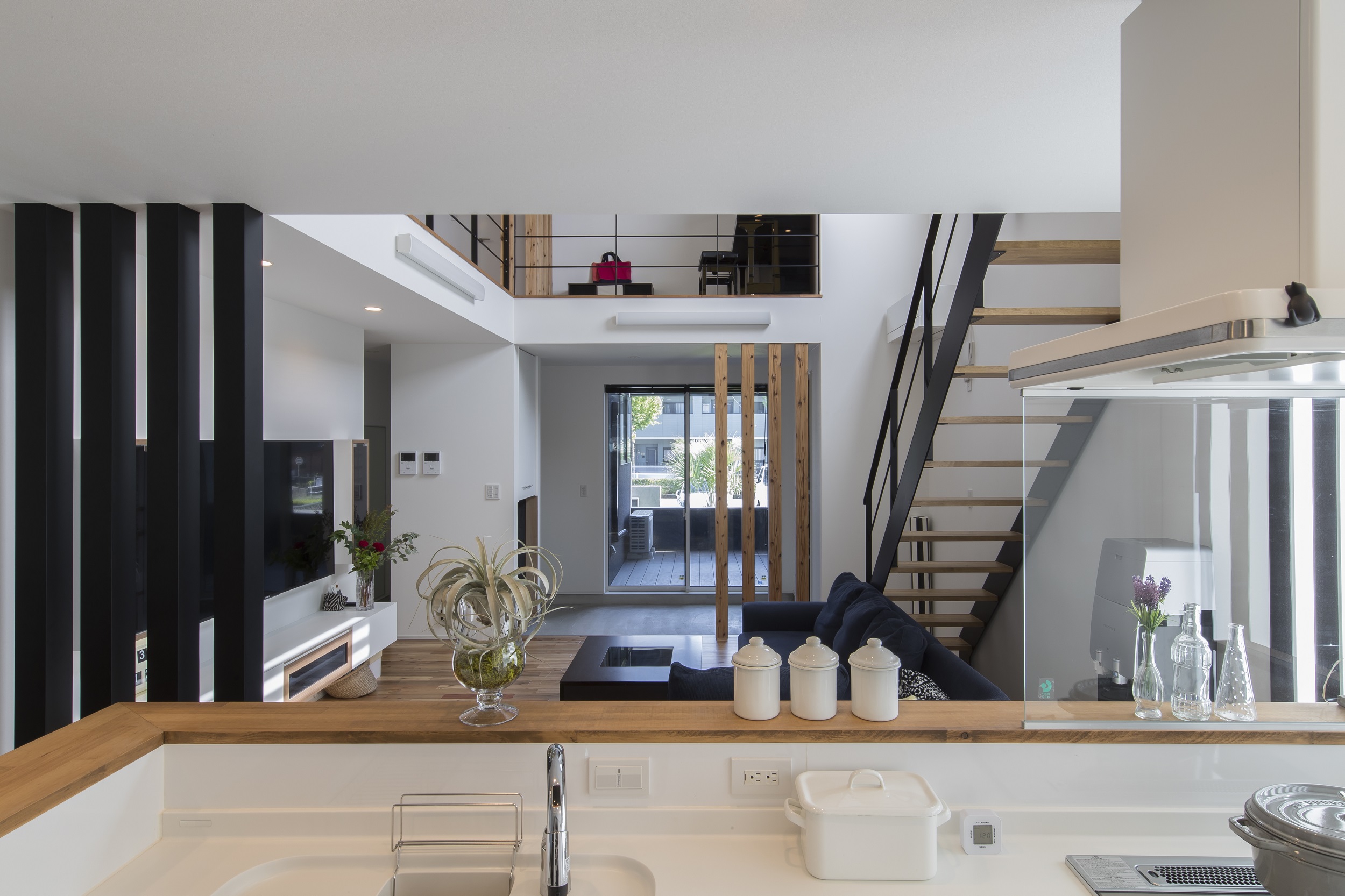 S.CONNECT（エスコネクト）【デザイン住宅、子育て、建築家】キッチンに立つと、土間やテラスで遊ぶ様子はもちろん、2階でピアノを練習する様子まで見渡せる。「どこにいても子どもの様子がよくわかるんです」と嬉しそうな奥さん。吹抜けが上下階をつなぎ、のびやかな空間が広がる