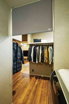 水回りエリアの奥には日常使いの服を収納するファミリークローゼットを配置。その先はリビングへとつながる。水回りエリアには木目のクッションフロアを選び、居住空間との連続性を大切にした