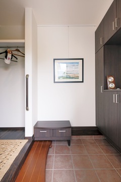 増築した玄関ホールは、段差を抑えたバリアフリー仕様に。絵画教室に通うご主人が描いた傑作がシンプルな空間を彩る