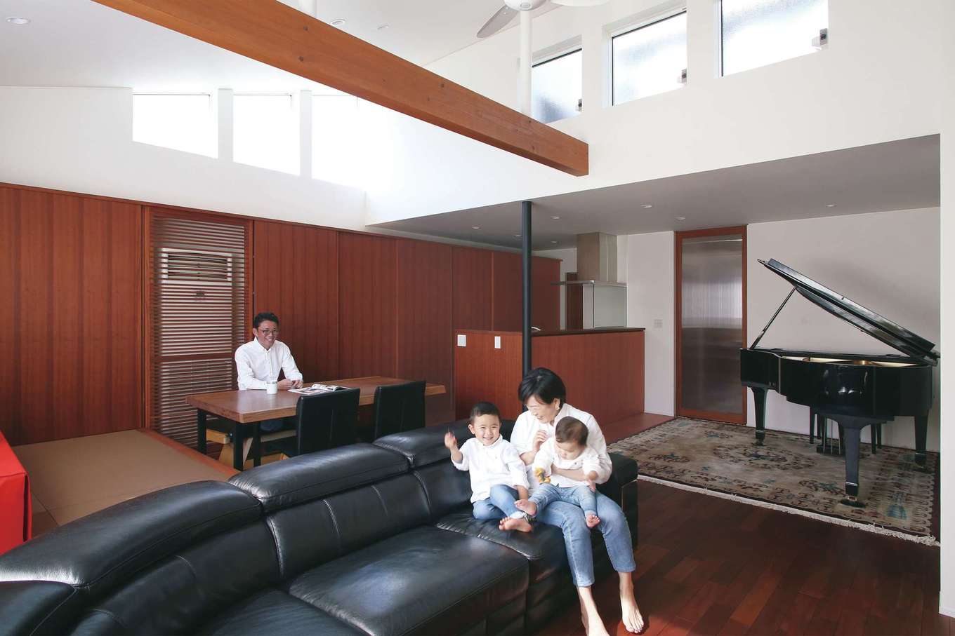 神谷綜合建設 カミヤの家【デザイン住宅、収納力、二世帯住宅】高さのある勾配天井と高窓により、開放感と明るさは抜群。グランドピアノを置いても広々。サペリの落ち着いた色合いも相まって、重厚感ある空間に仕上がった。