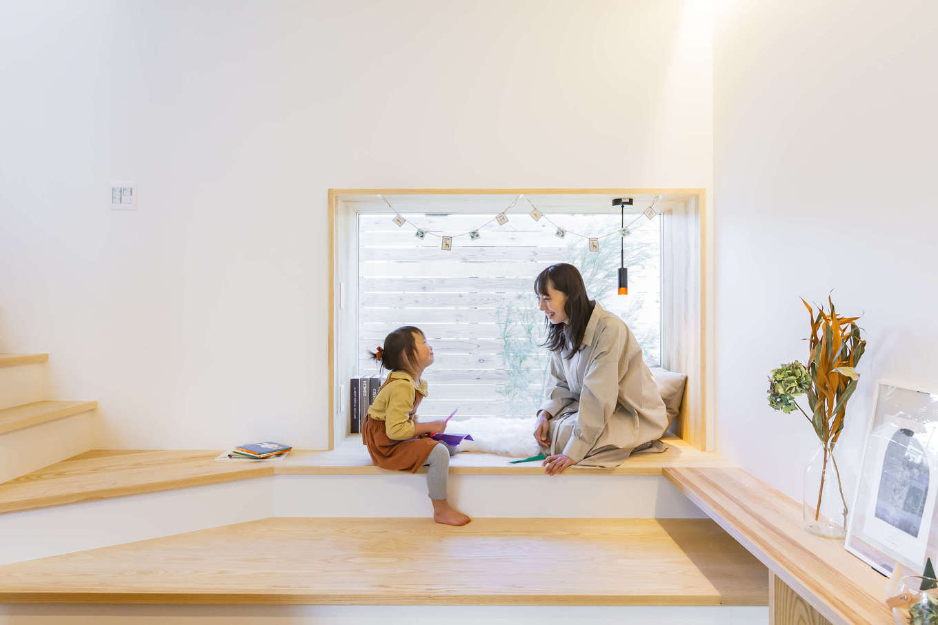 ARRCH アーチ【デザイン住宅、間取り、平屋】リビングと階段の間にある小上がりのヌックでは、北側の庭を眺めながら子どもと一緒に遊んだり、絵本を読んだり、ホームパーティでは腰掛けとして利用したり。中庭テラスとはひと味違った楽しみ方ができる