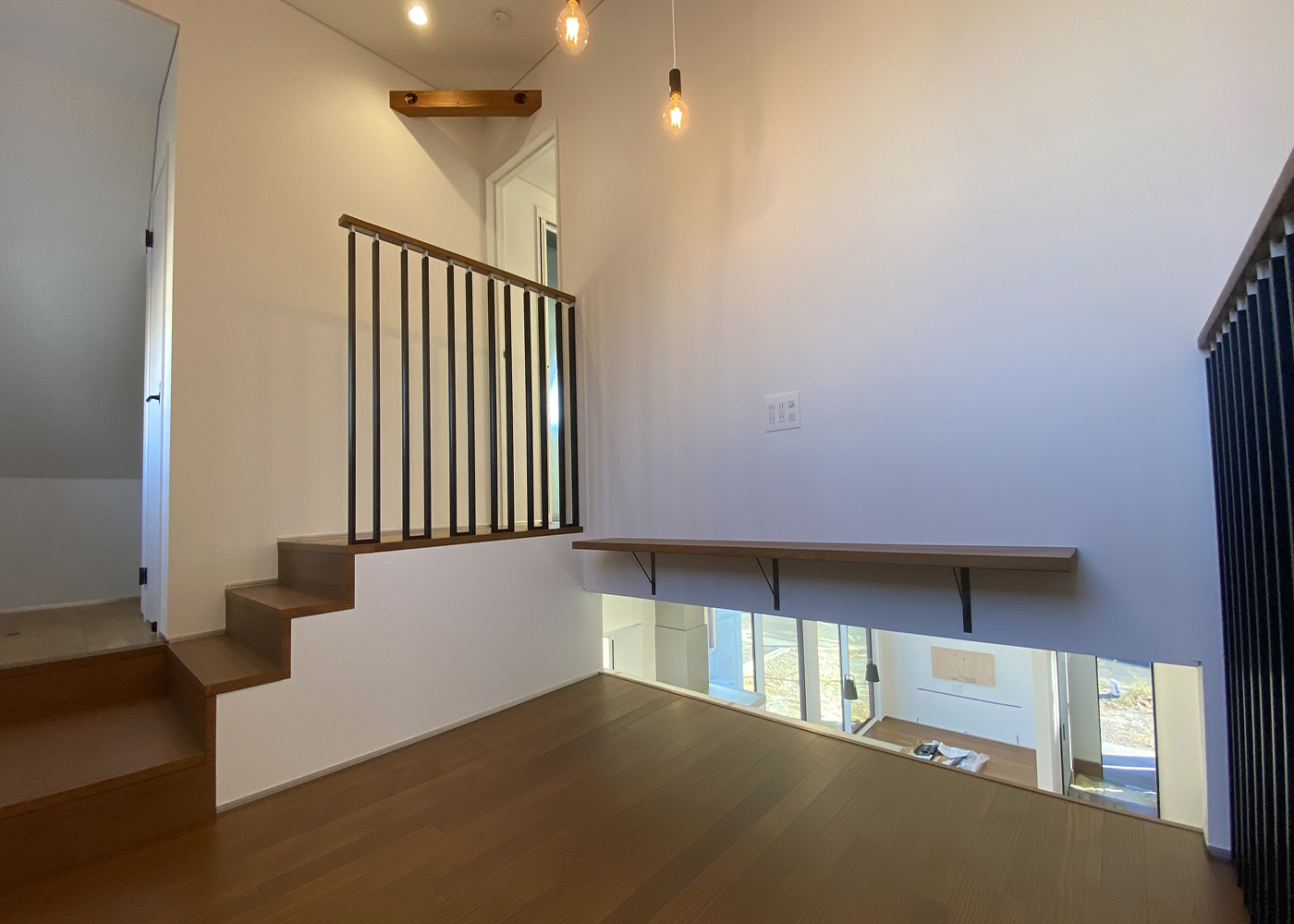 ぽっくハウス豊橋店（東海ハウス豊橋）【デザイン住宅、趣味、スキップフロア】スキップフロアからもリビングダイニングの様子がわかる。左はトイレと納戸で、階段を上ると主寝室と子ども室がある