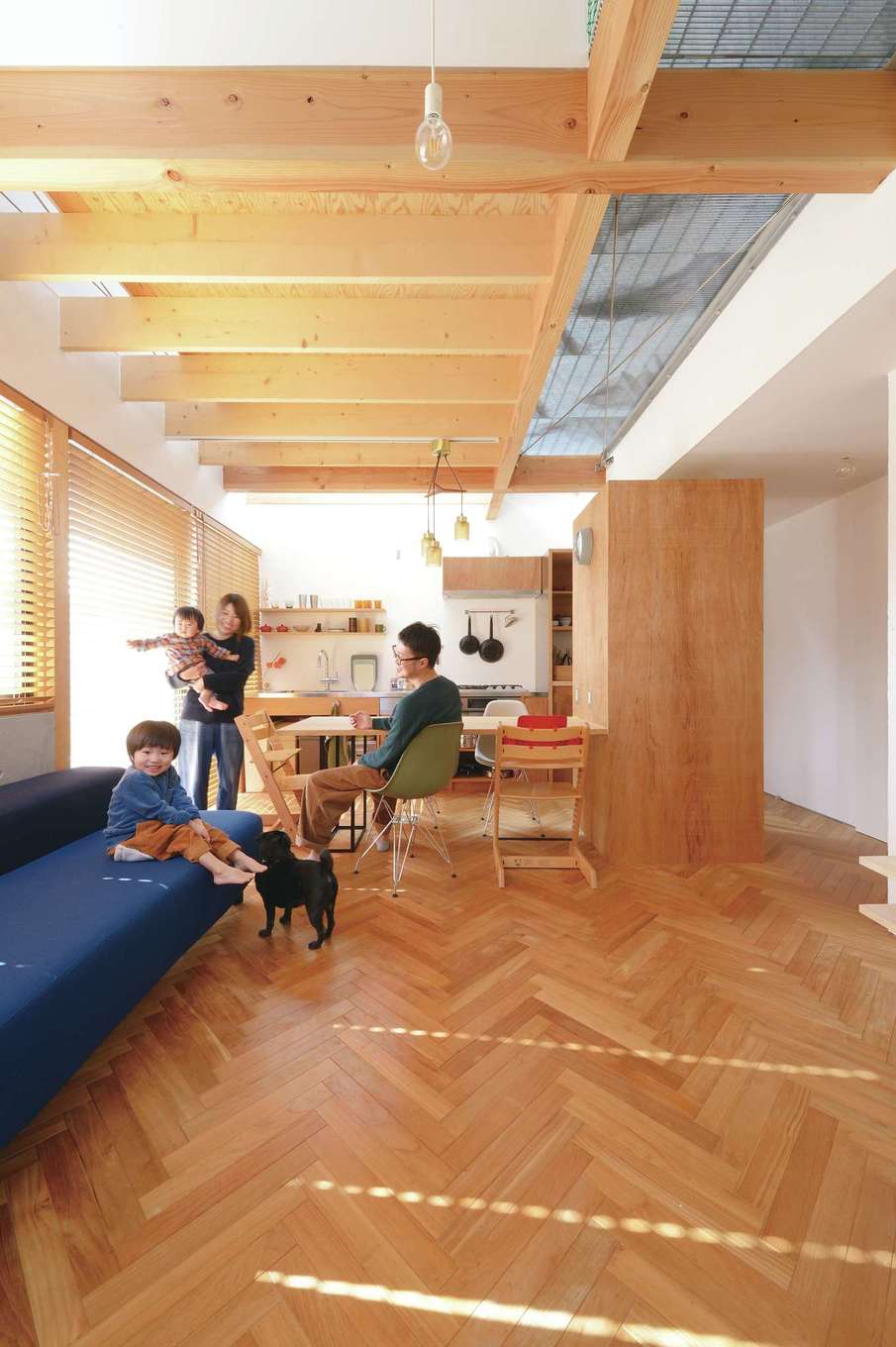 MABUCHI【デザイン住宅、狭小住宅、間取り】吹抜けで1階と2階が繋がり、実寸以上の広さを感じさせるオープンなLDK。高窓から注ぐ光が室内全体に行き渡る。2階の廊下には金属をスノコ状にした土木建築材のグレーチングを使用。光と視線が抜ける開放的な空間で、家族が一体感を味わえる