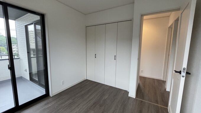 ガラスの引き戸でバルコニーとつながる明るい居室。クローゼット付きで収納力も十分、使い勝手の良い空間である。