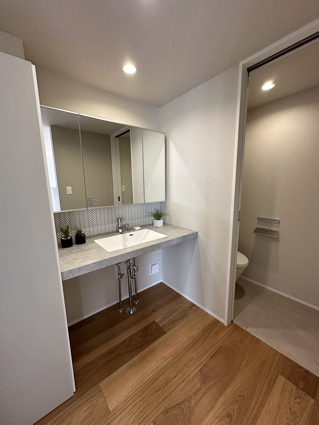 BASE.trip【デザイン住宅、間取り、インテリア】脱衣室と洗面室を別々にしたので使いやすい。おしゃれな造作洗面台は、人気のアイカの「スタイリッシュカウンター」が標準仕様。ミラーBOXの下にヘリンボーンのタイルを張って上質な雰囲気を演出した