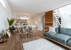 木のぬくもりを感じる大人ナチュラルなLDK。家族とのコミュニケーションをとりやすいオープンキッチンを採用。肌触りのいいヘリンボーンの床は無垢のオーク材で、経年変化も楽しみ