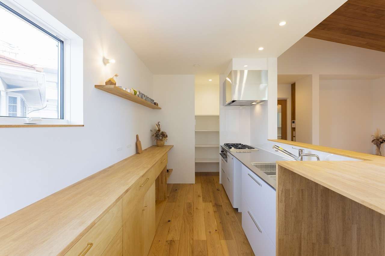 温戸ライフ【子育て、狭小住宅、インテリア】装飾用の木の板でカウンターを造作したキッチンが印象的。奥にはパントリーを備えている