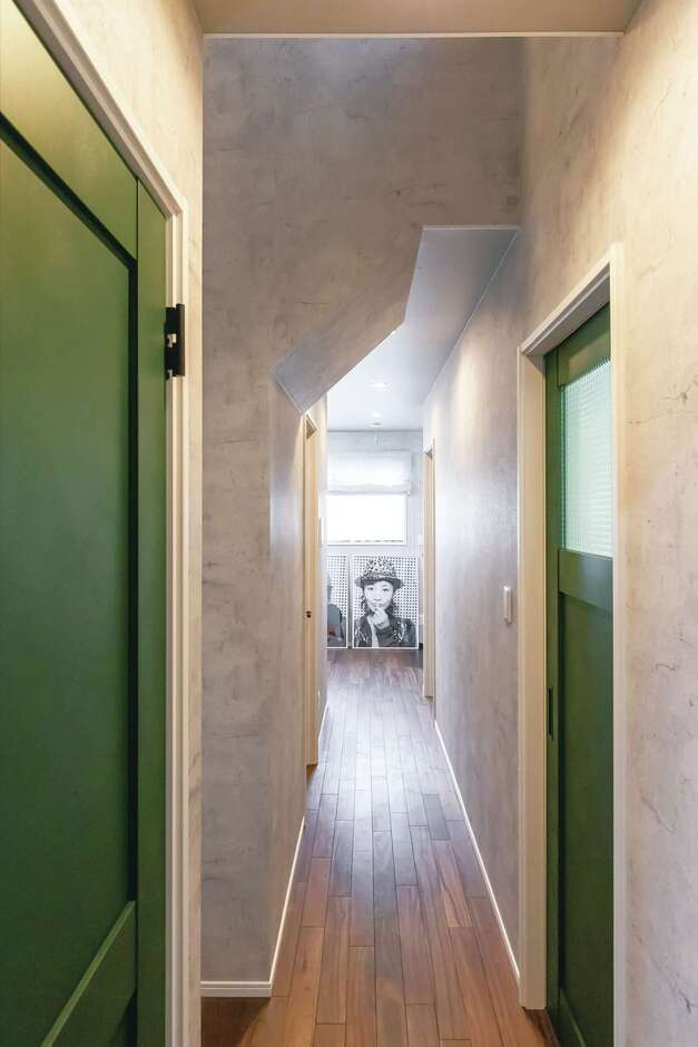 NYのアパートを彷彿とさせる長い廊下。マットな質感の建具がニュアンスを与える